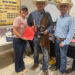 Three people wearing cowboy hats and boots.